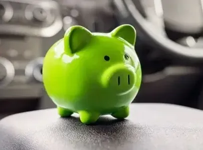 A green piggy bank on a car's dashboard, symbolizing savings and financial planning.